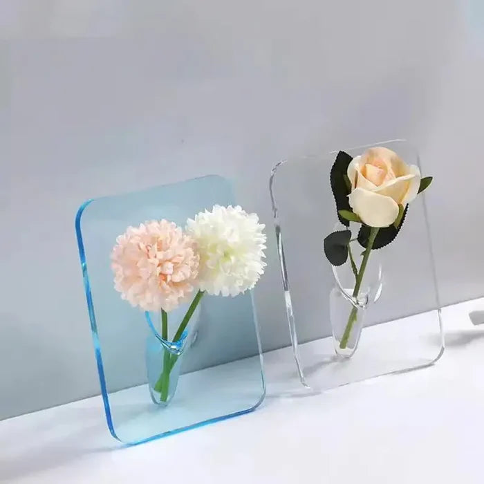 Two Acrylic Frame Vase pieces in blue and clear acrylic, each holding delicate pastel flowers, showcasing minimalist elegance and modern home decor style.
