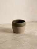 Ceramic cup with two-tone design on a textured surface