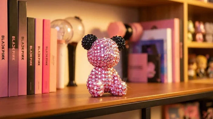 Blackpink Bear Figurine with black accents on a shelf with books and decorative items.