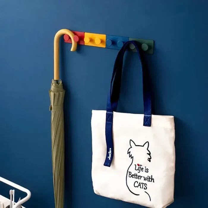 Canvas tote bag with cat design and 'Life is Better with CATS' text, hanging on colorful wall hooks