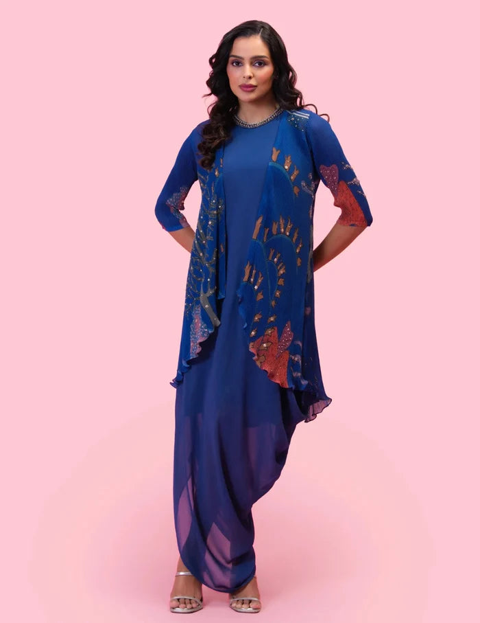 Model wearing the 'BRAHMAND BLUE' DRAPED DRESS WITH OVERLAY JACKET featuring an embroidered neckline and a printed micro-pleated Georgette jacket