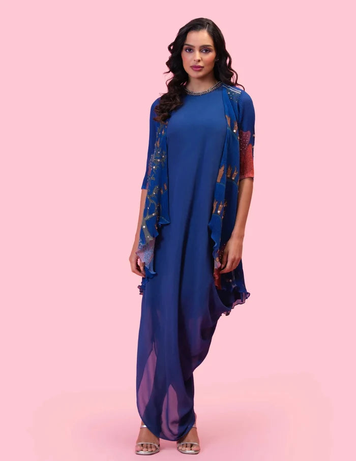 Model wearing the 'BRAHMAND BLUE' DRAPED DRESS WITH OVERLAY JACKET featuring an embroidered neckline and a printed micro-pleated Georgette jacket