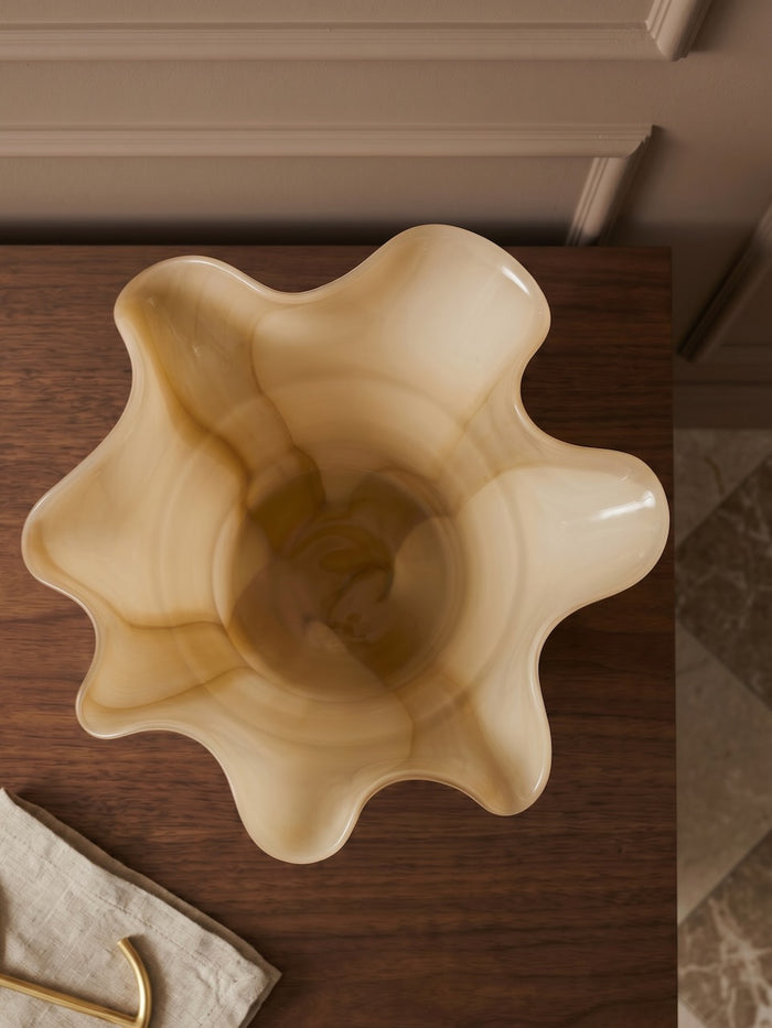 Decorative beige vase on a wooden surface