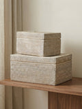 white rattan storage boxes stacked on wooden shelf in neutral living room