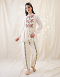 White Gulzaar Appliquéd Peplum Top with front tie-ups paired with straight linen pants, offering an elegant and refined contemporary silhouette.