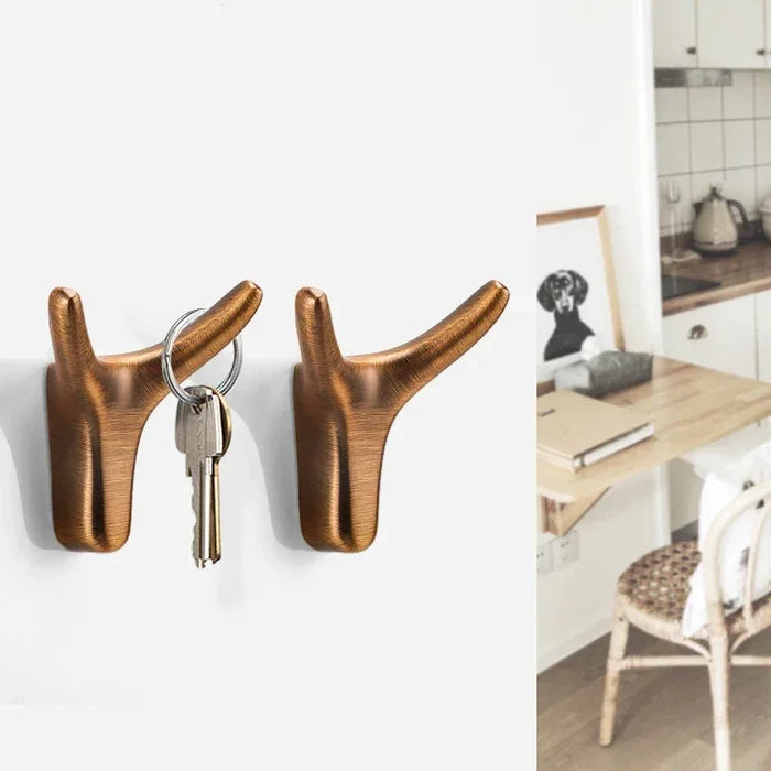 Brass deer antler wall hooks holding keys, modern home decor with warm aesthetic