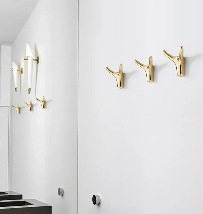 Gold antler-style wall hooks for modern home décor, adding warmth and personality to minimalist spaces.