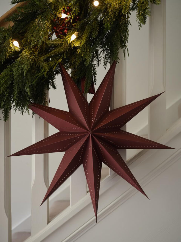 Burgundy Paper Star Decoration hanging on staircase.