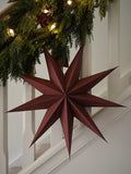 Burgundy Paper Star Decoration hanging on staircase.