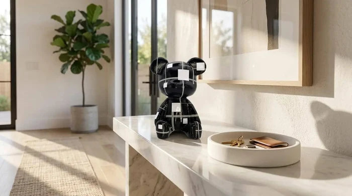 Black bear figurine with white geometric patterns on a marble console table in a modern entryway