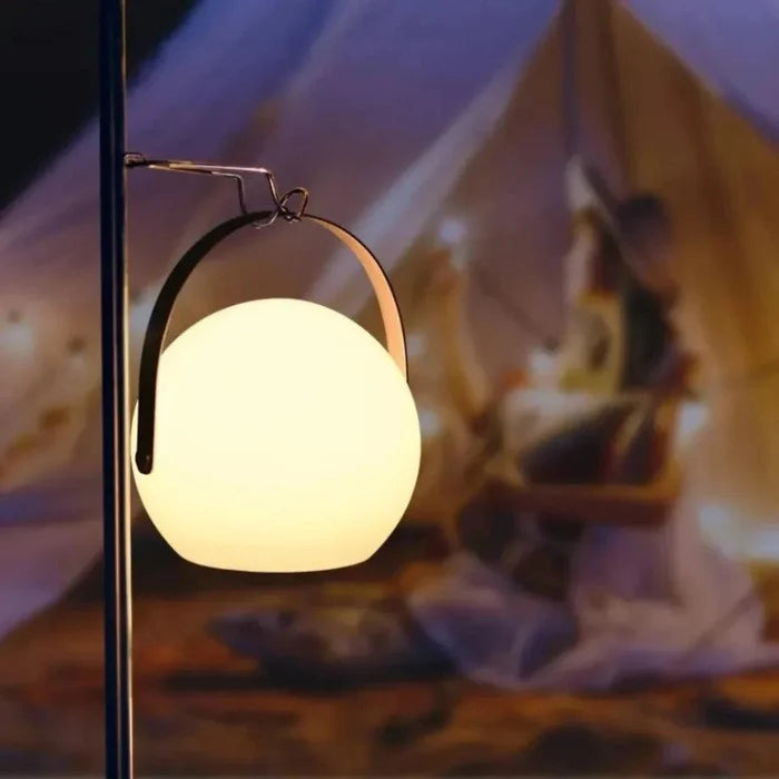 Glowing spherical lantern with metal handle, warm ambient lighting for cozy home décor